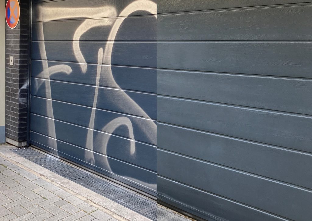Garage mit Graffiti. Rechte Hälfte mit Graffitientfernung